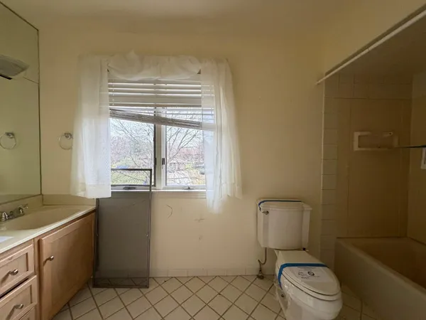 a bathroom with a granite countertop toilet a sink and a bathtub