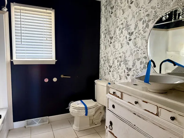 a bathroom with a sink toilet and window