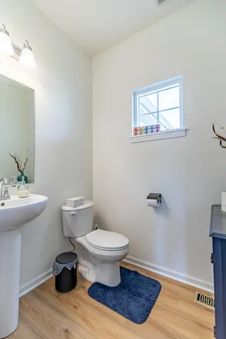 a view of staircase with lots of frames on wall and wooden floor