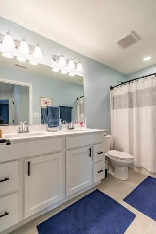 a view of a white house with a big yard and a large tree