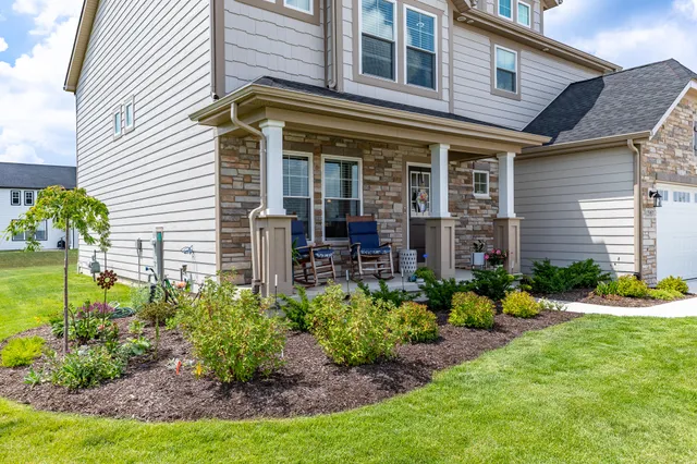 a front view of a house with garden and plants