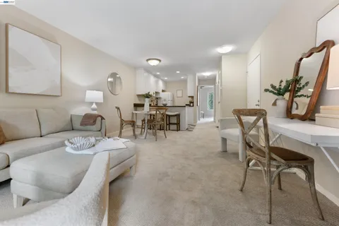 a living room with furniture and kitchen view