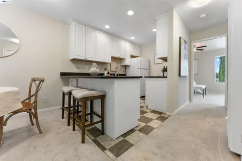a kitchen with stainless steel appliances granite countertop table chairs sink and cabinets