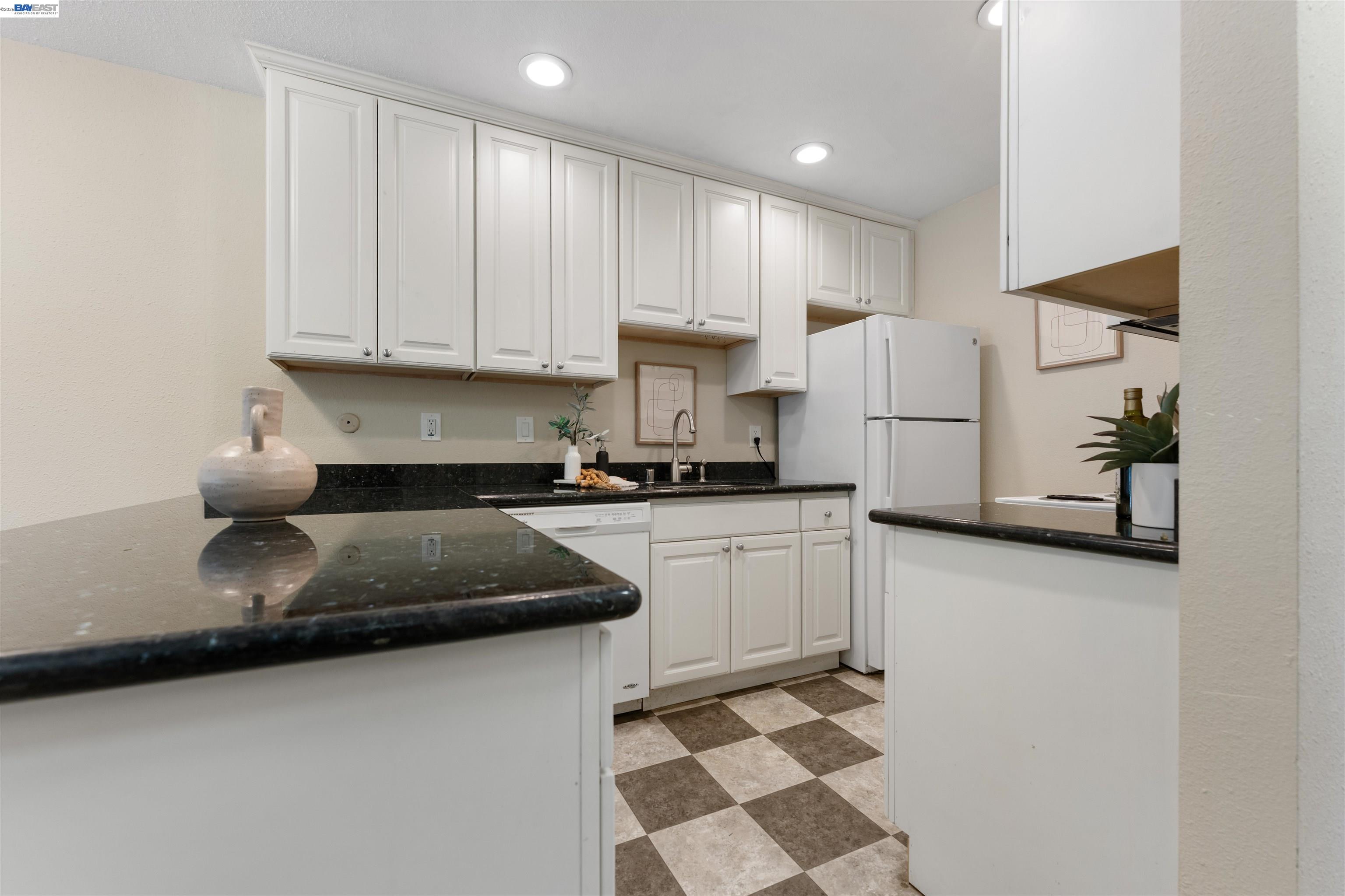 4081 Clayton Road, Unit 221 Concord, CA 94521 - Photo 9 of 23 a kitchen with stainless steel appliances granite countertop a refrigerator sink and white cabinets