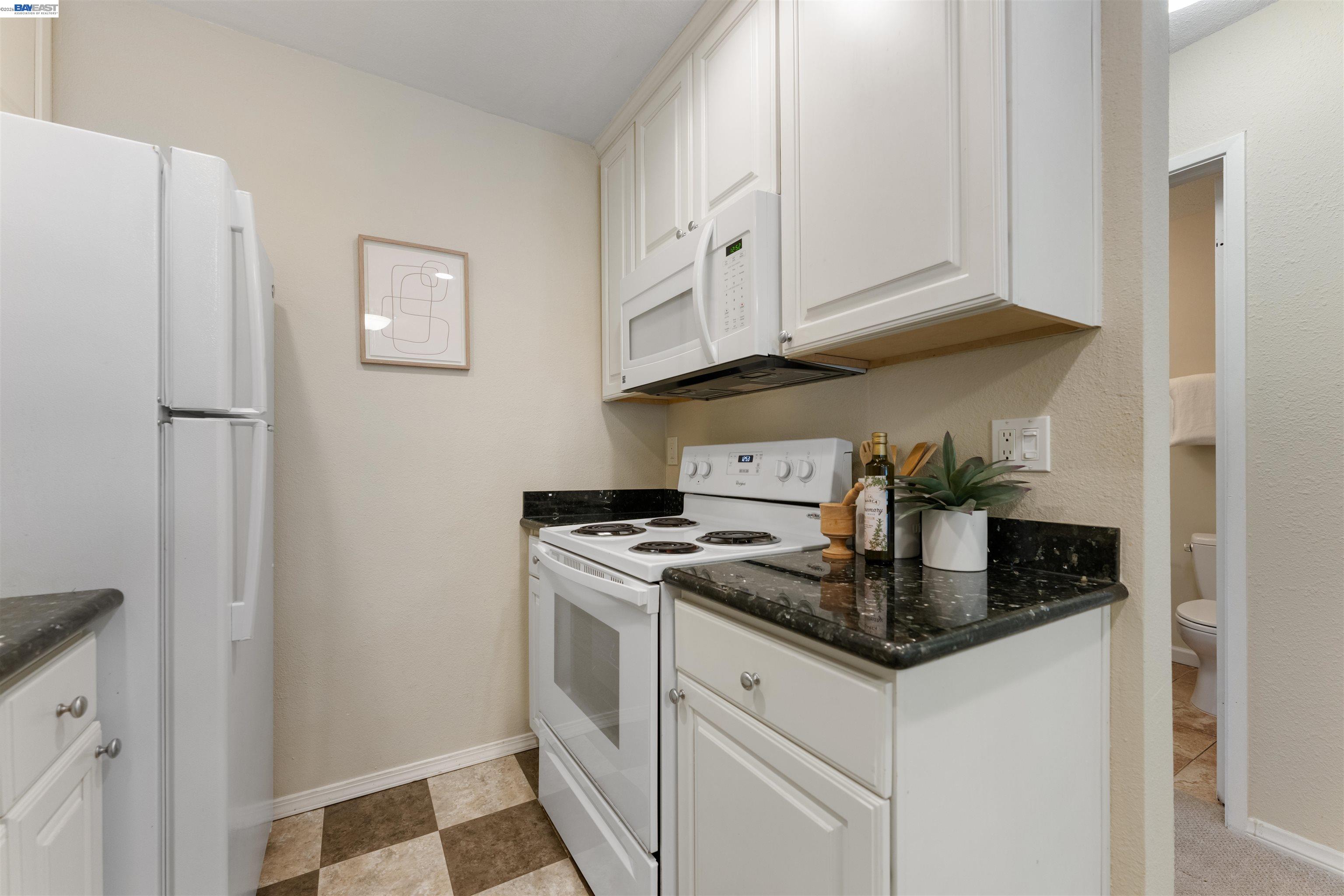 4081 Clayton Road, Unit 221 Concord, CA 94521 - Photo 10 of 23 a kitchen with stainless steel appliances granite countertop a refrigerator sink and white cabinets