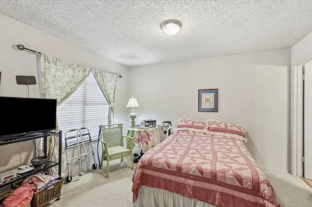 a bedroom with a bed a flat screen tv and dresser