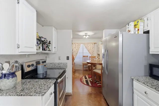 a kitchen with stainless steel appliances granite countertop a refrigerator and a sink