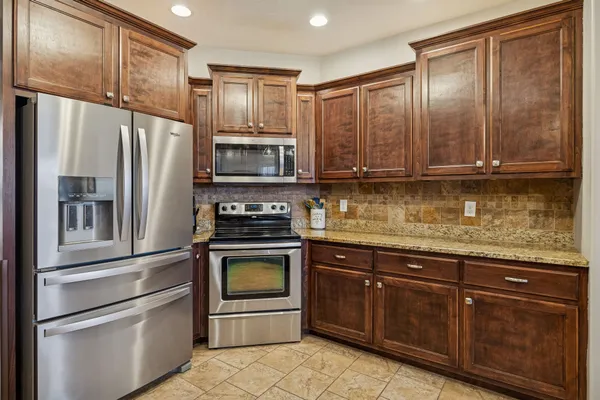 a kitchen with granite countertop stainless steel appliances and wooden cabinets