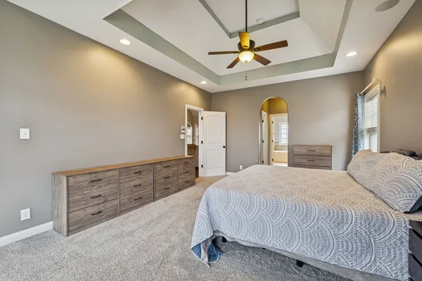 a bedroom with a bed and a ceiling fan
