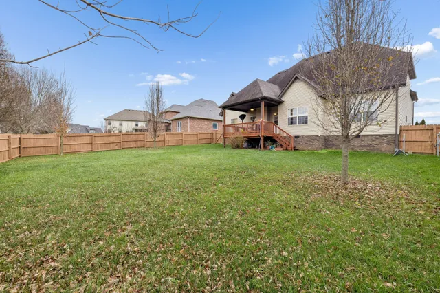 a view of a house with a big yard and large trees