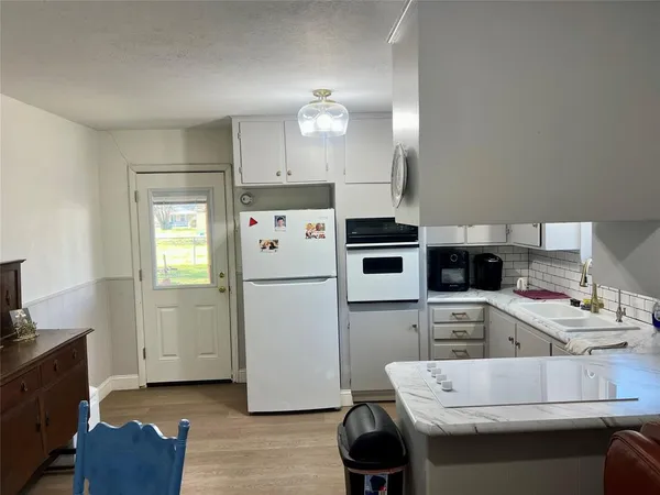 a kitchen with a sink a refrigerator and cabinets