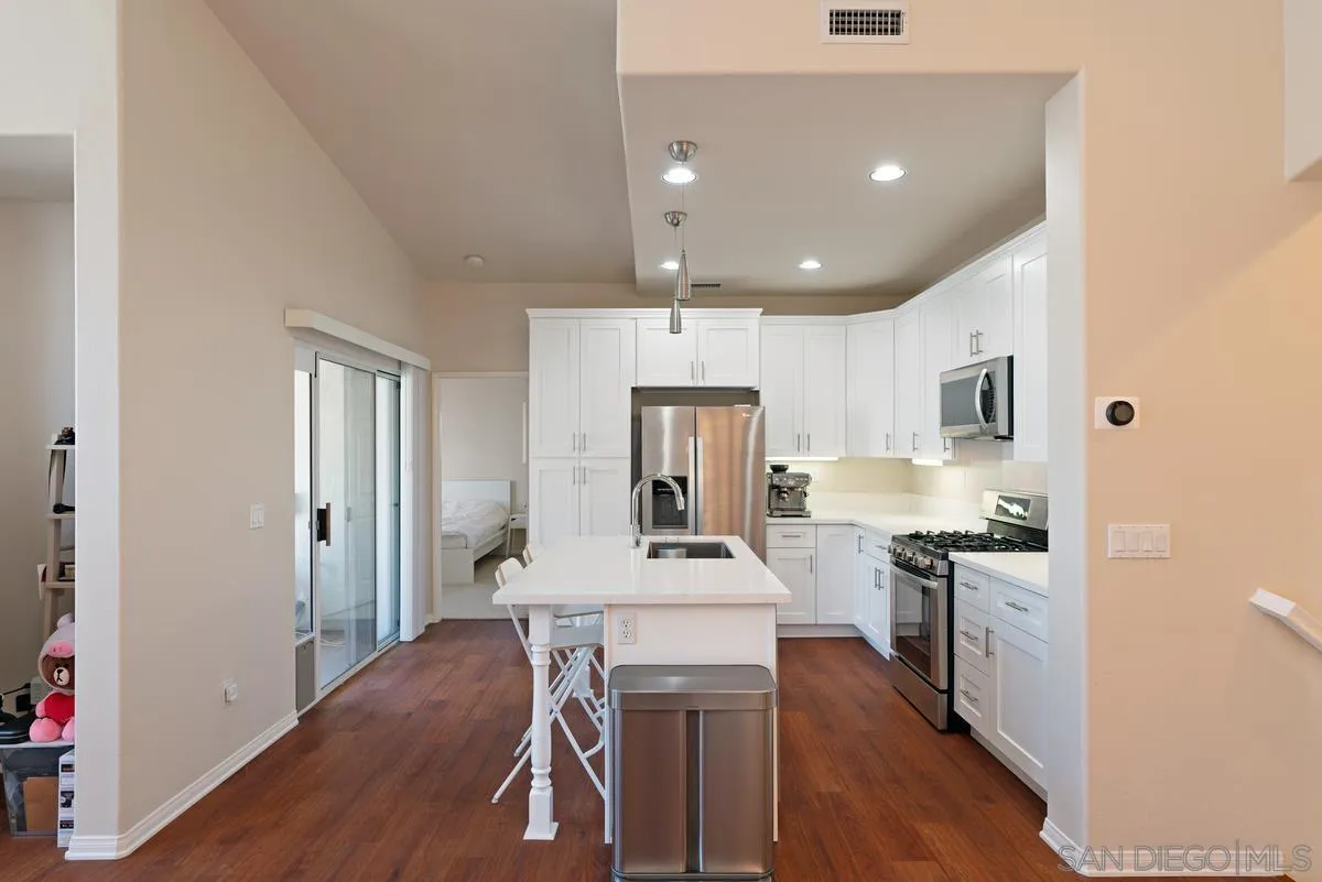 11456 Miro Circle San Diego, CA 92131 - Photo 13 of 34 a kitchen with kitchen island a counter top space a sink stainless steel appliances and cabinets