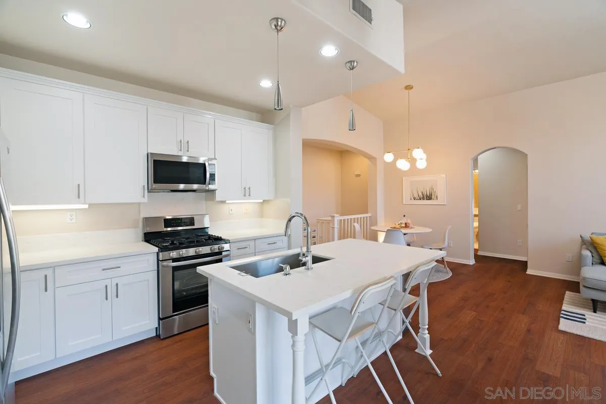 11456 Miro Circle San Diego, CA 92131 - Photo 17 of 34 a kitchen that has a sink a stove counter space and cabinets