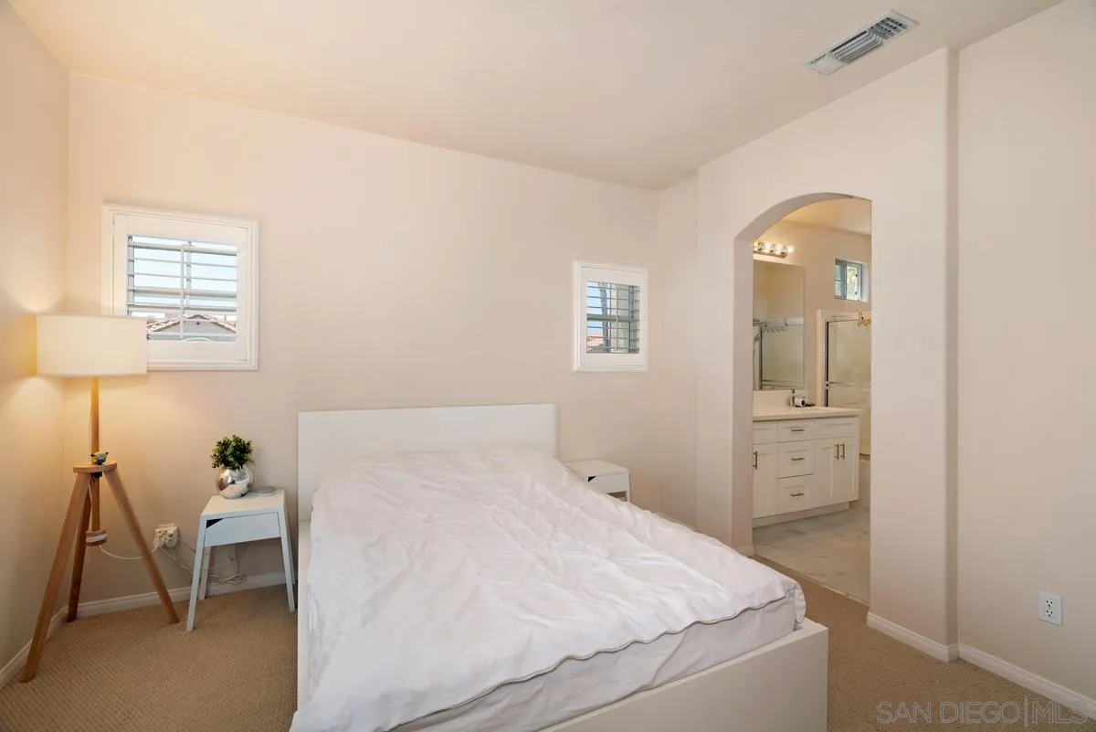 11456 Miro Circle San Diego, CA 92131 - Photo 20 of 34 a bedroom with a bed and a lamp on the dresser
