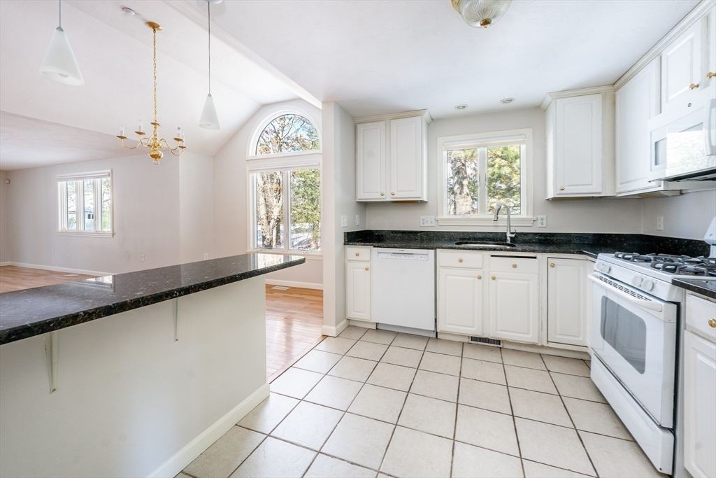 13 Pga Lane, Unit 424 Mashpee, MA 02649 - Photo 7 of 19 a kitchen with a sink a stove cabinets and a window