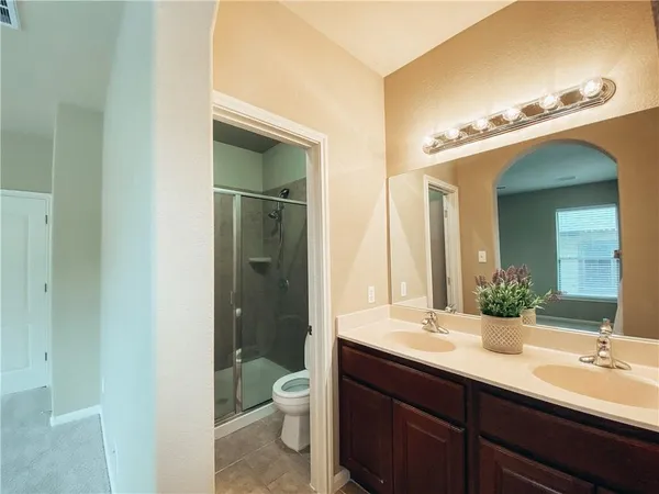 a bathroom with a double vanity sink toilet and shower