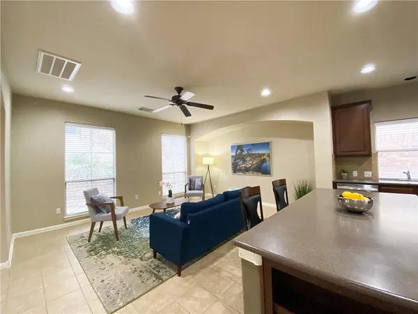 a living room with furniture and a dining table with wooden floor