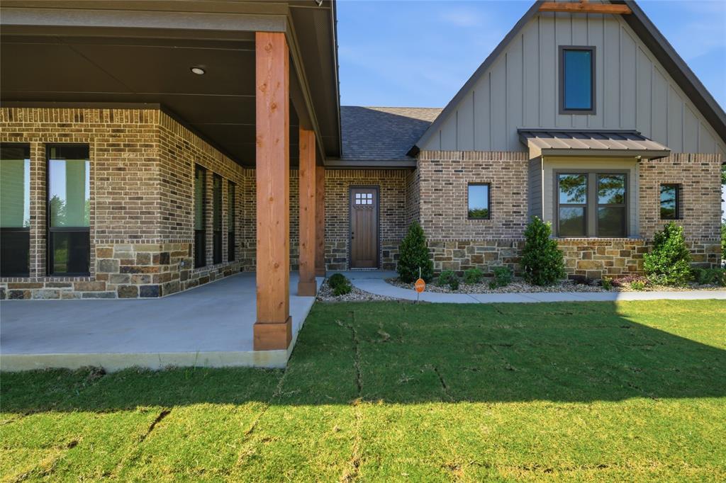 958 Cedar Mills Road Gordonville, TX 76245 - Photo 4 of 40 a view of a house with brick walls and a yard with plants