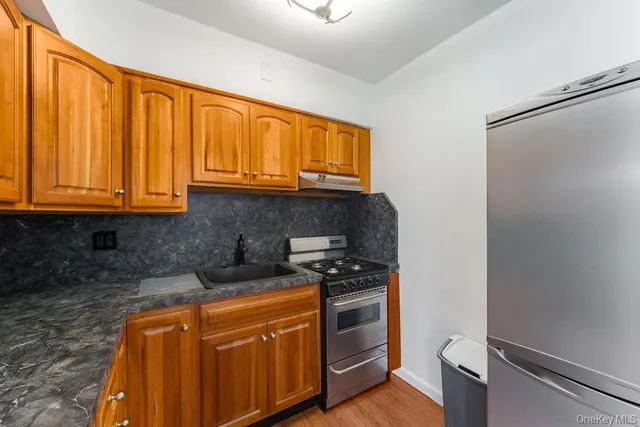 a kitchen with stainless steel appliances granite countertop a stove a sink and a refrigerator
