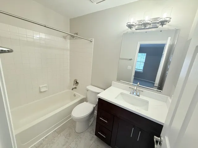 a bathroom with a sink a toilet a mirror a bathtub and shower