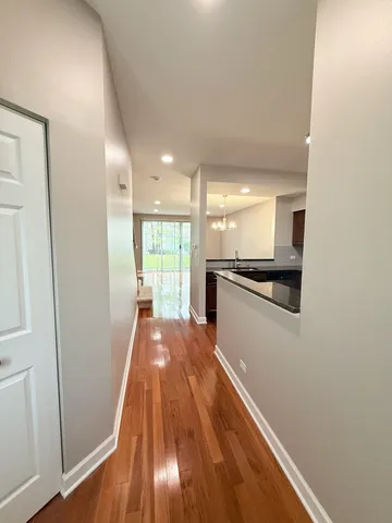 a view of a kitchen with wooden floor and a window