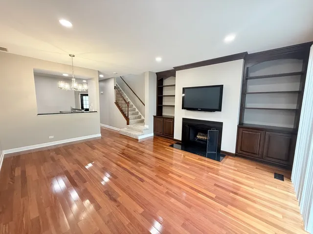 a view of a livingroom with a fireplace a flat screen tv and staircase