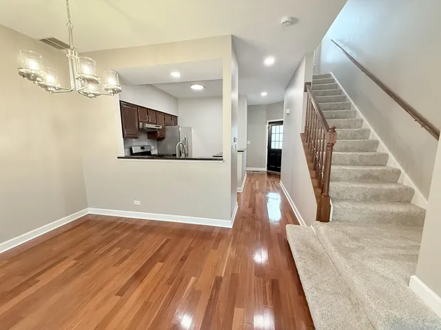a view of a livingroom with wooden floor and a ceiling fan