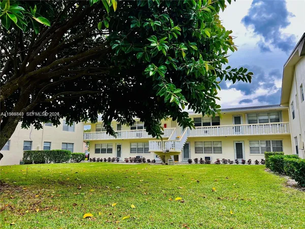 a front view of a building with a garden