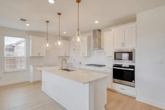 a kitchen that has a sink a stove and a wooden floor