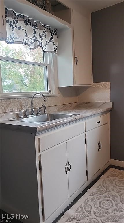 23621 Colbourne Road Euclid, OH 44123 - Photo 44 of 45 Kitchen featuring white cabinets, backsplash, and sink