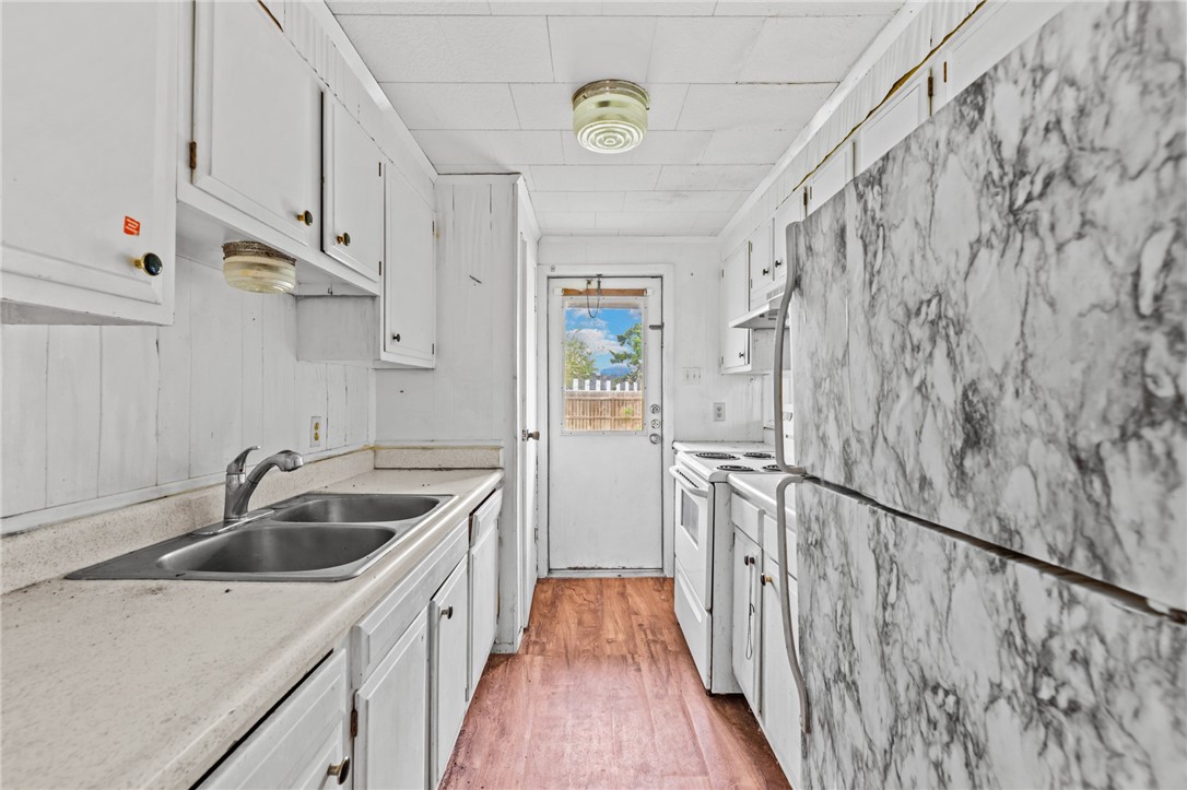 1011 Northcliff Drive Portland, TX 78374 - Photo 7 of 16 a kitchen that has a sink and a oven with wooden floor
