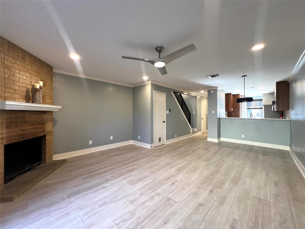 3801 Menchaca Road, Unit 50 Austin, TX 78704 - Photo 12 of 30 an empty room with wooden floor a fireplace and entryway