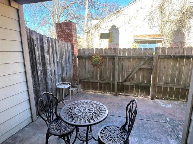 a view of a patio with a table and chairs and potted plants