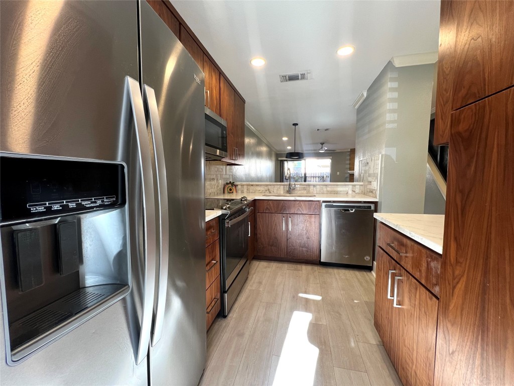 3801 Menchaca Road, Unit 50 Austin, TX 78704 - Photo 9 of 30 a kitchen with stainless steel appliances granite countertop a refrigerator a stove and a sink