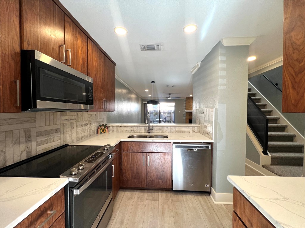 3801 Menchaca Road, Unit 50 Austin, TX 78704 - Photo 10 of 30 a kitchen with stainless steel appliances granite countertop a sink a stove and a wooden floors