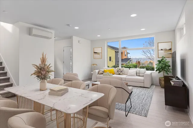 a living room with furniture kitchen view and a large window
