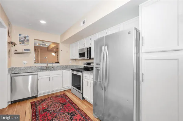 a kitchen with stainless steel appliances granite countertop a refrigerator and stove top oven
