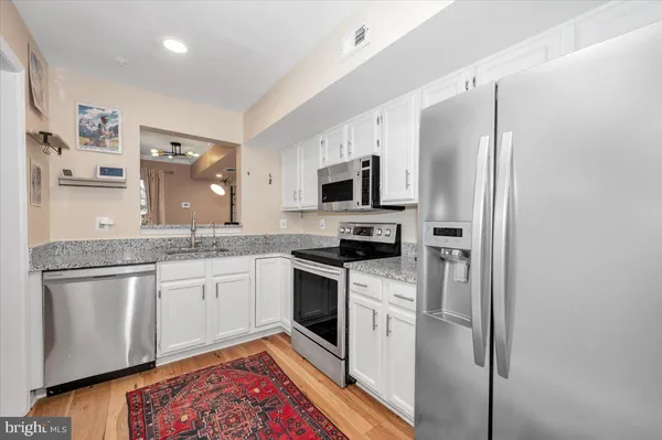 a kitchen with stainless steel appliances granite countertop a refrigerator a stove top oven a sink and dishwasher