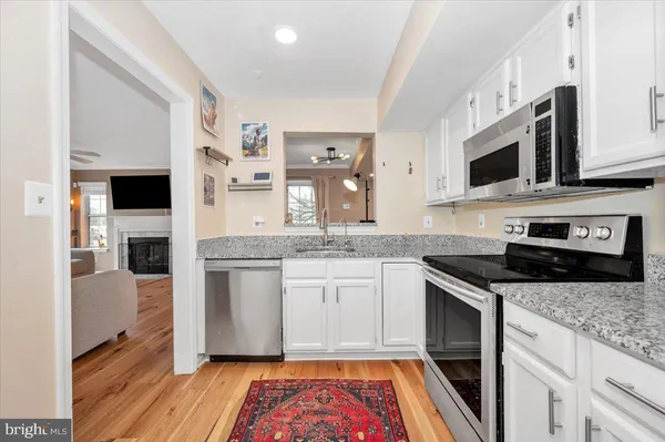 a kitchen with stainless steel appliances granite countertop a stove and a microwave