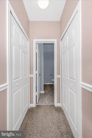 a view of a hallway with wooden floor and closet
