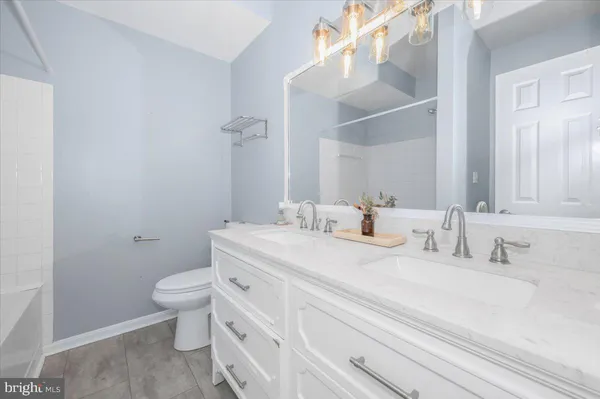 a bathroom with a granite countertop sink mirror vanity and toilet