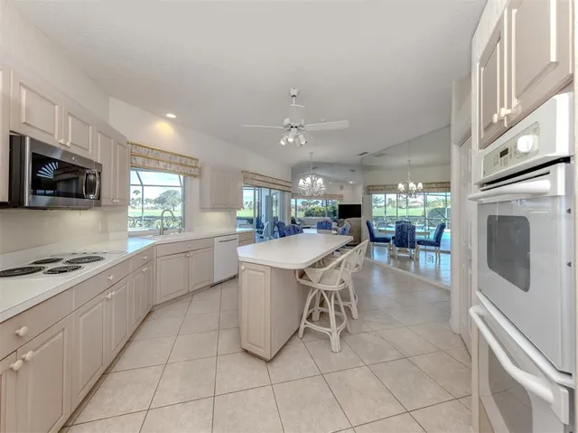 a kitchen with kitchen island a counter top space appliances and cabinets