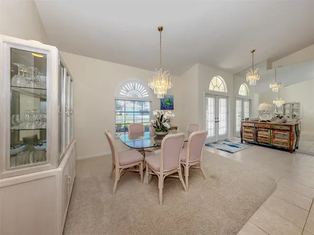 a kitchen with stainless steel appliances kitchen island granite countertop a sink a stove a microwave a dining table and chairs