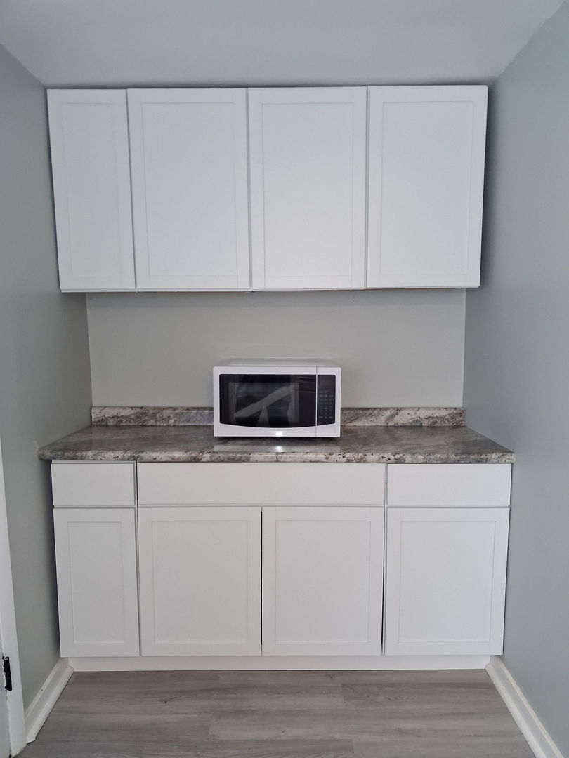 1353 Harding Avenue, Unit 3 Des Plaines, IL 60016 - Photo 8 of 14 a kitchen with stainless steel appliances granite countertop white cabinets and a granite counter tops