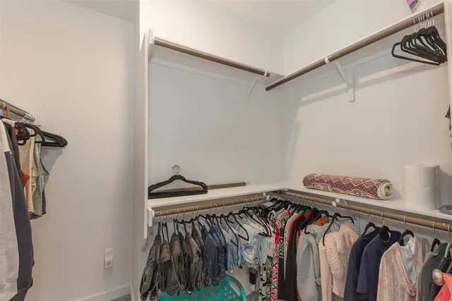 a view of walk in closet with clothes and shoes