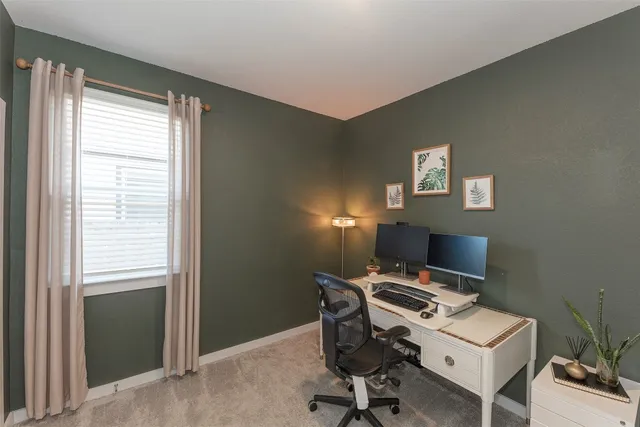 a view of a workspace with furniture and a window