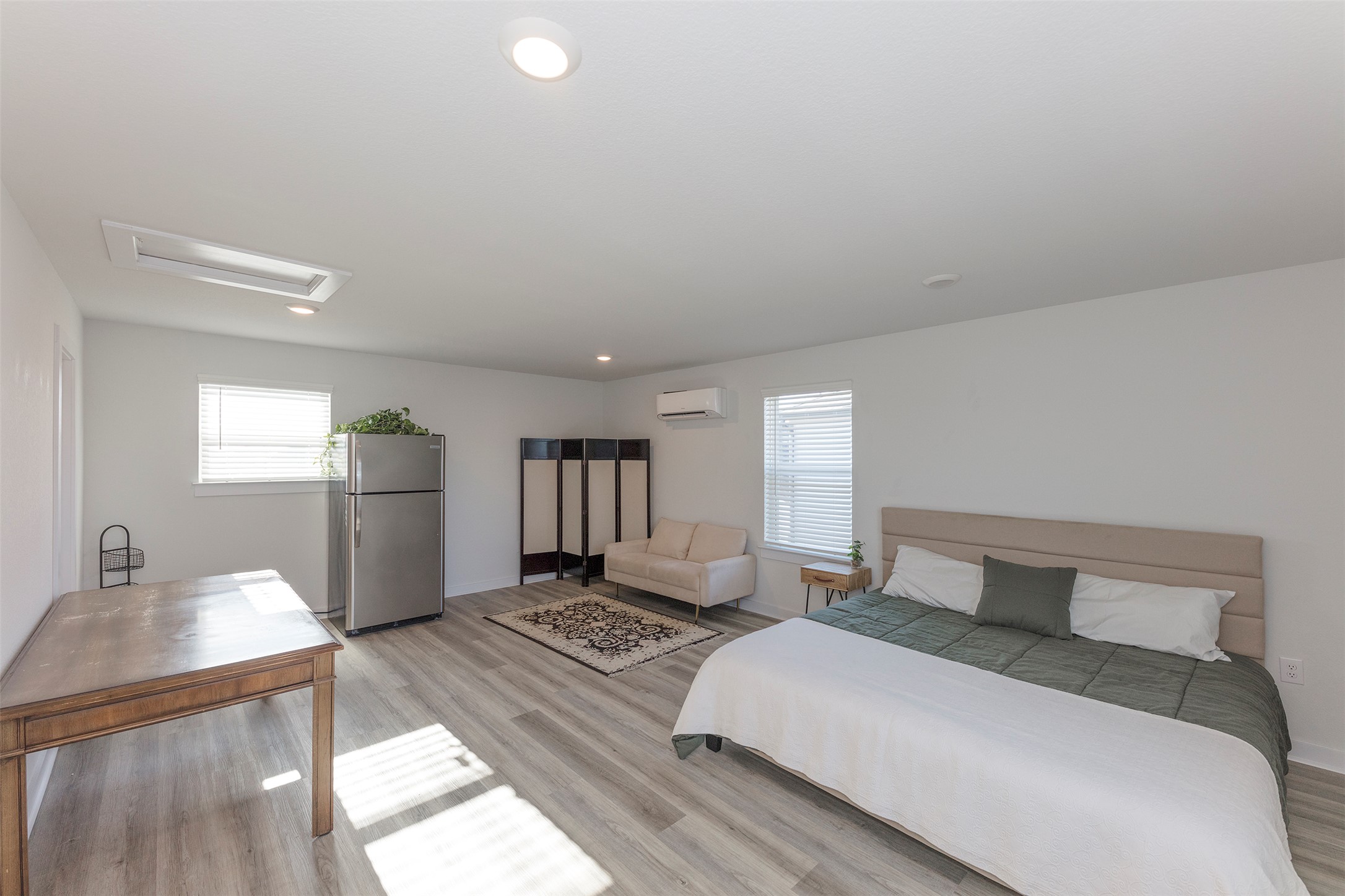 236 Garner Drive Kyle, TX 78640 - Photo 24 of 37 Bedroom with attic access, freestanding refrigerator, light wood-style flooring, multiple windows, and recessed lighting