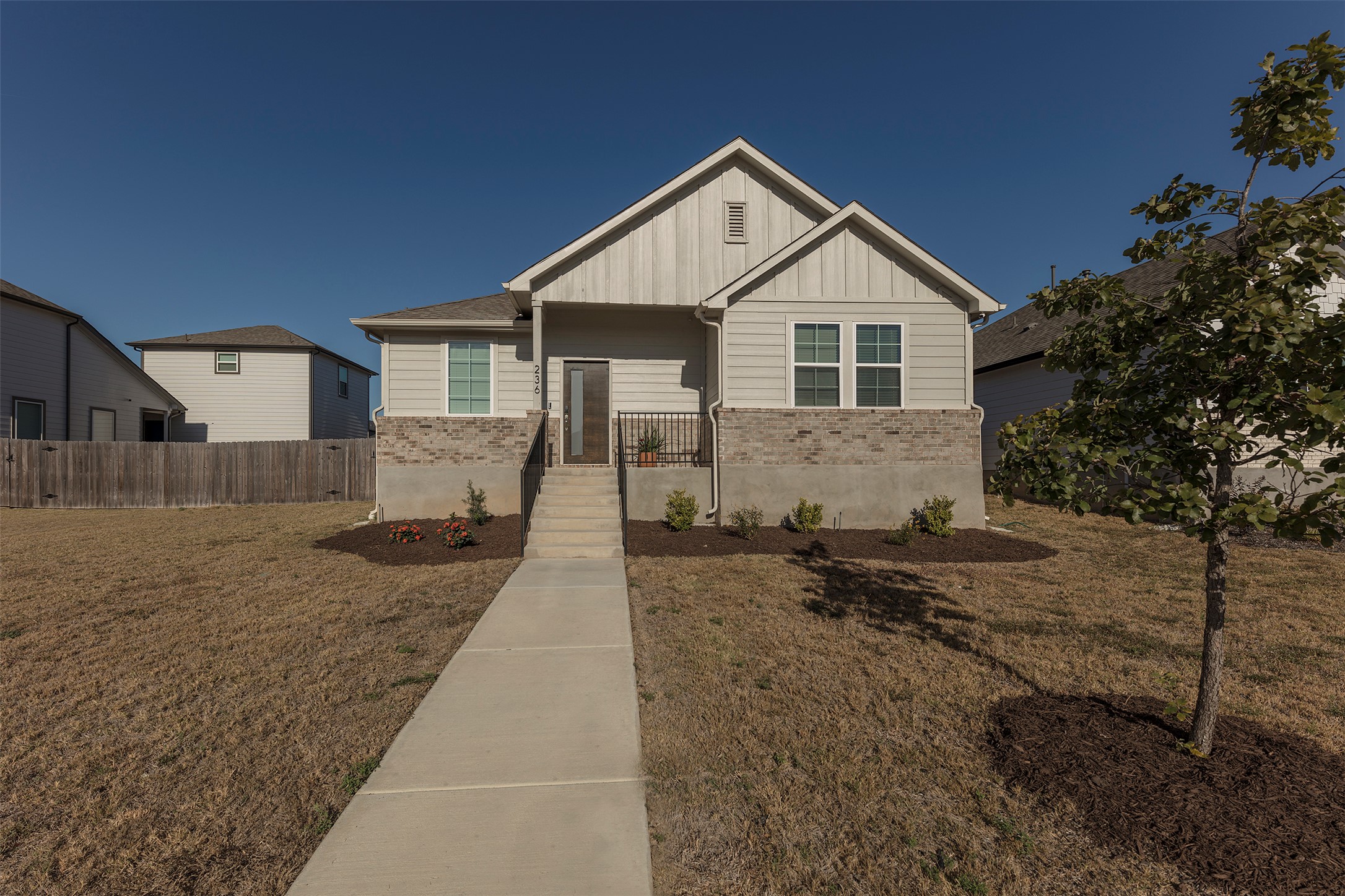 236 Garner Drive Kyle, TX 78640 - Photo 30 of 37 View of front of home with board and batten siding, brick siding, and covered porch