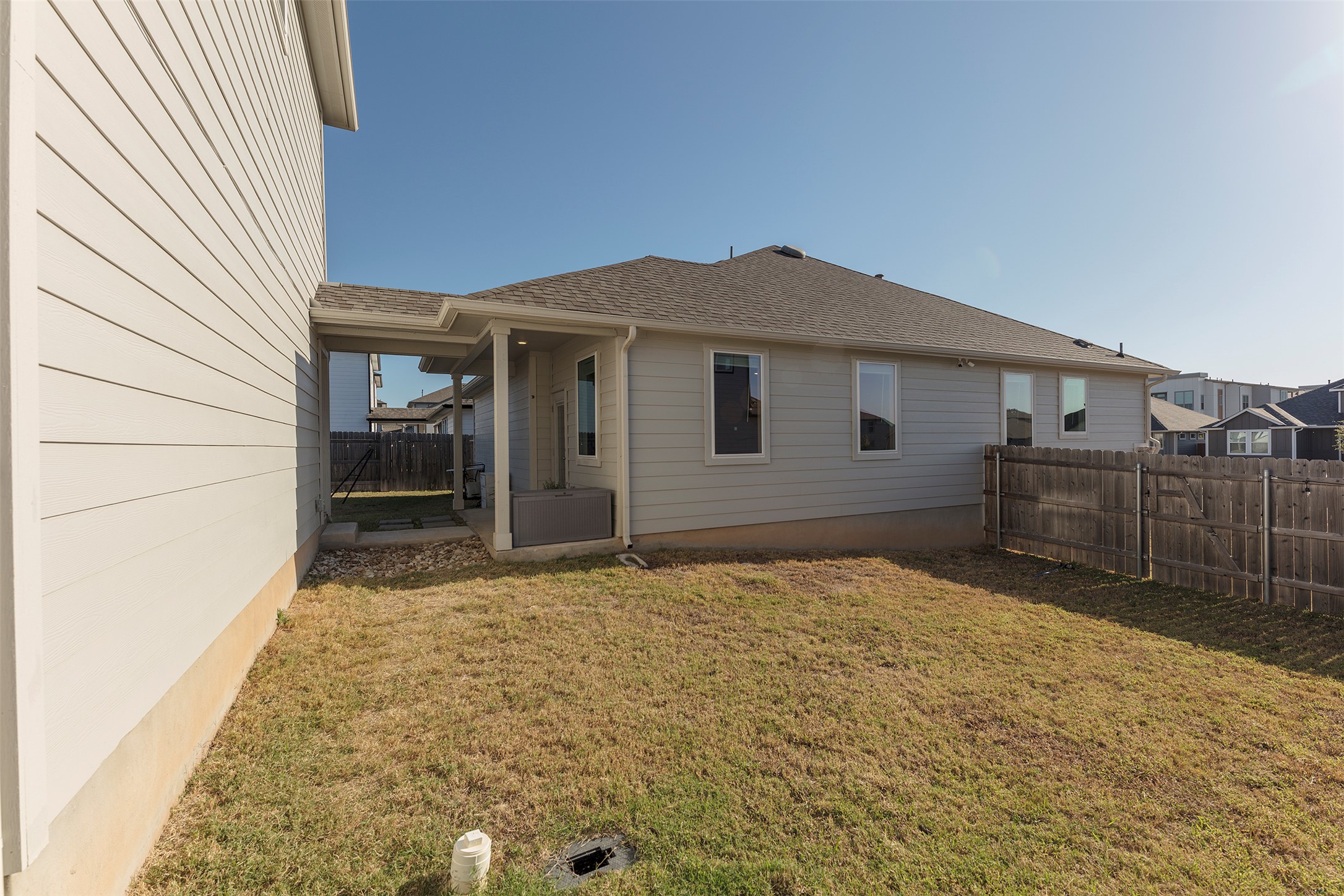 236 Garner Drive Kyle, TX 78640 - Photo 34 of 37 Rear view of house featuring a shingled roof, a fenced backyard, and a patio