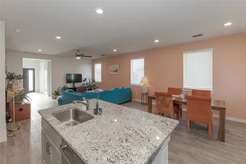 a kitchen with stainless steel appliances granite countertop a table and chairs in it